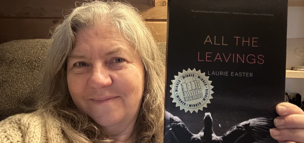 Laurie Easter showing her book "All the Leavings "
